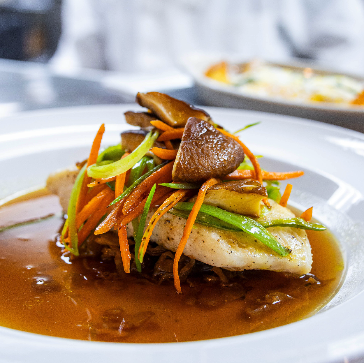 Pan-seared halibut with julienned vegetables, shiitake mushrooms and ginger broth