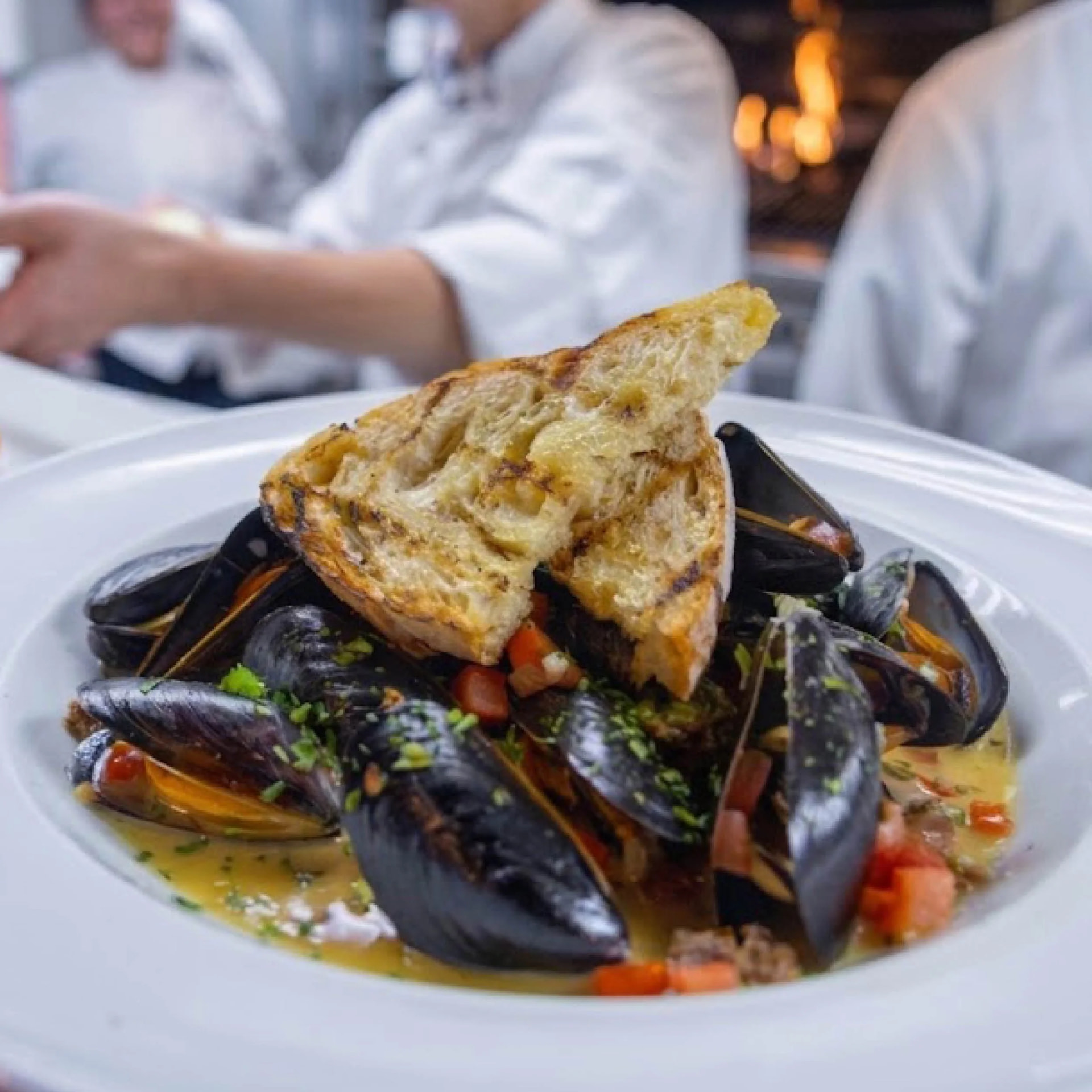 Steamed mussels in saffron broth with tomato, herbs and grilled sourdough